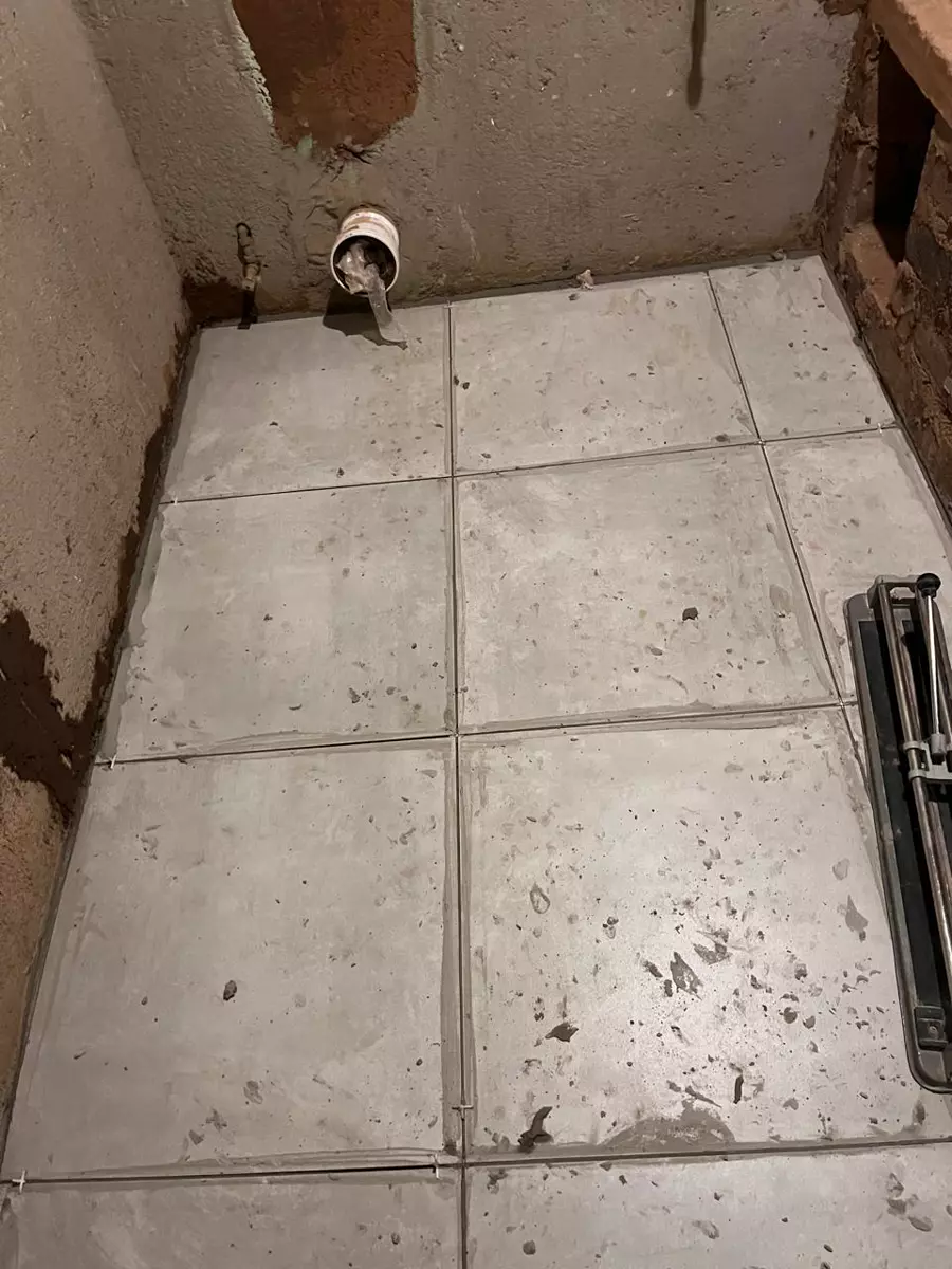 Room under construction with newly laid grey tiles on the floor