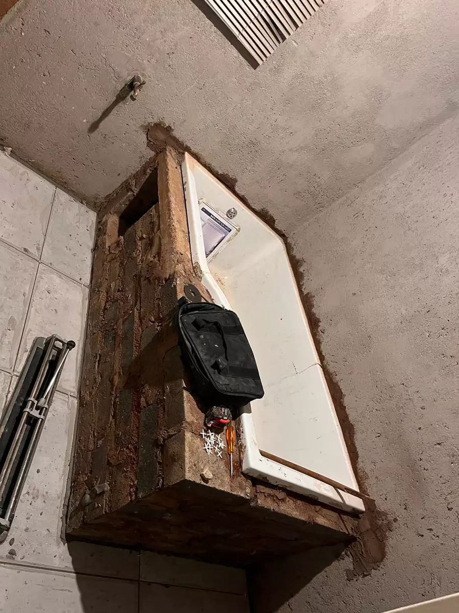 Bathtub installation in progress in a room with unfinished walls